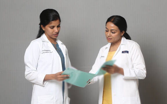 Dr Mangalam Raman and Dr Vani Sundarapandian reading a case file together at Jananam Fertility Centre