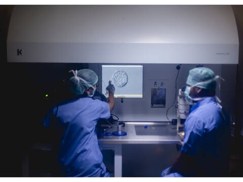 A Jananam embryologist in gloves working at a microscope in the IVF lab at the Neelankarai hospital, Chennai