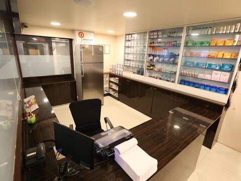 The on-site pharmacy at Jananam Fertility Centre, Neelankarai, with medicines in glass-fronted cabinets and a refrigerator