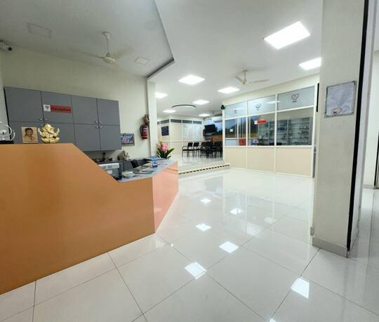 The reception desk at Jananam Fertility Centre, Thiruporur, with the waiting area and the pharmacy beyond